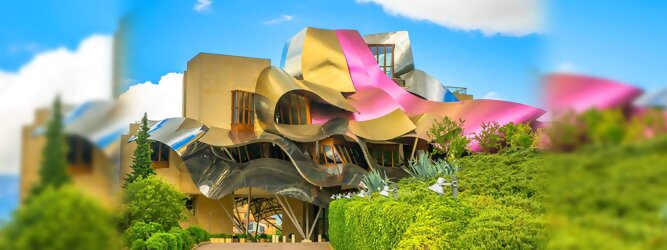 Trip Single Reisetipps - Marqués de Riscal Design Hotel, Bilbao, Elciego, Spanien. Fantastisch galaktisch, unverkennbar ein Werk von Frank O. Gehry. Inmitten idyllischer Weinberge in der Rioja Region des Baskenlandes, bezaubert das schimmernde Bauobjekt mit einer Struktur bunter, edel glänzender verflochtener Metallbänder. Glanz im Baskenland - Es muss etwas ganz Besonderes sein. Emotional, zukunftsweisend, einzigartig. Denn in dieser Region, etwa 133 km südlich von Bilbao, sind Weingüter normalerweise nicht für die Öffentlichkeit zugänglich.
